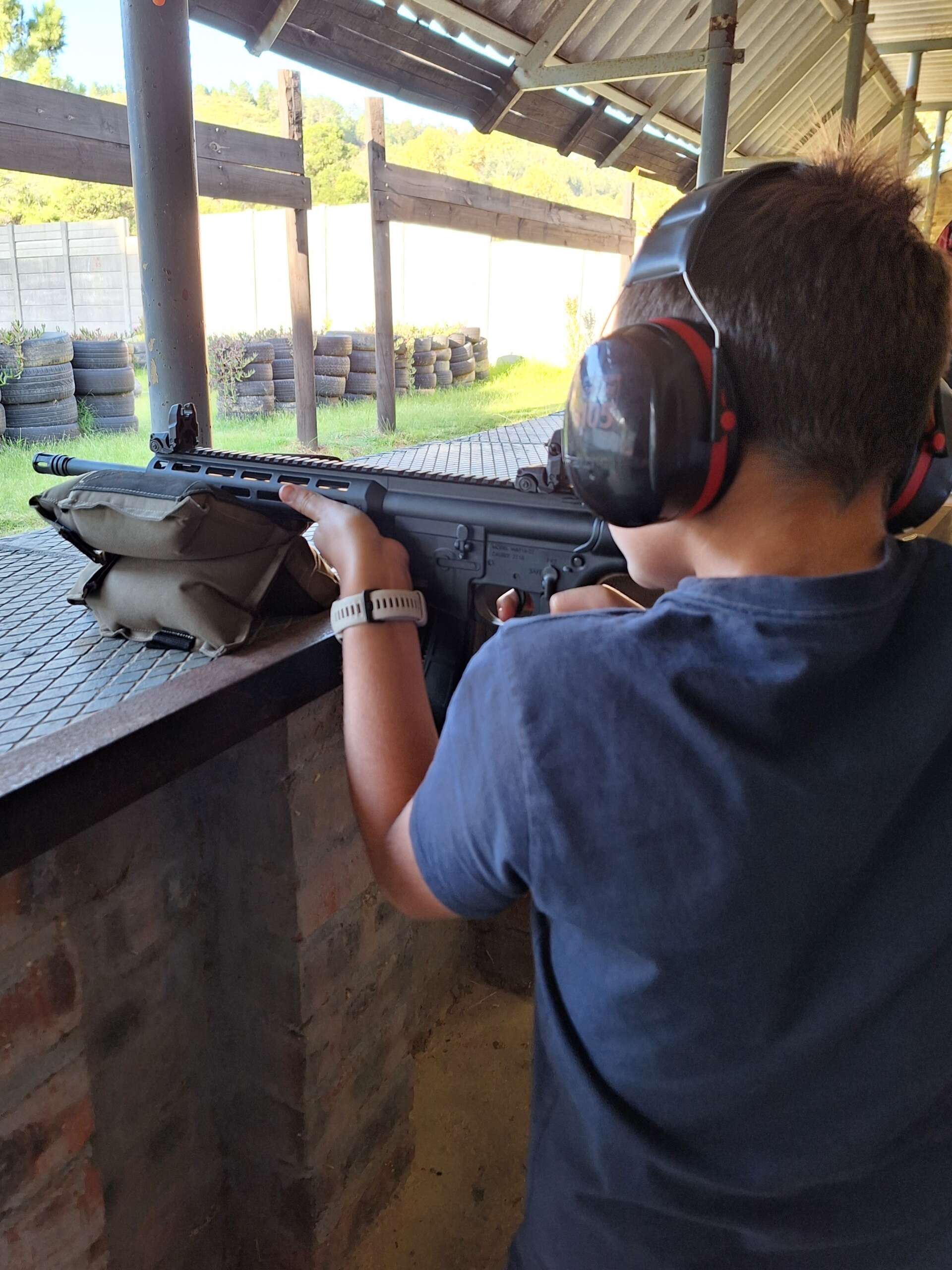 Youngster shooting a rifle under supervision.
